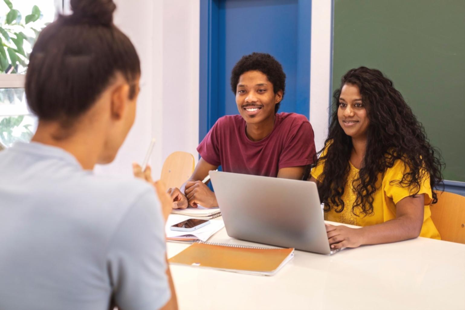 Modern workspace setup showing laptop and financial charts on screen